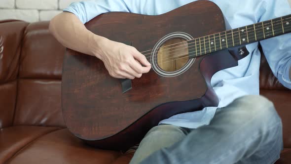 young Asian man playing guitar music and sing a song relax to record video live streaming