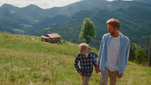 Happy Man Son Walking on Mountain Slope