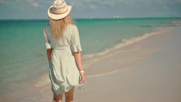 Woman Relaxing On Bahamas Flowing Dress Blowing In Wind.Travel Mood Wind Blows Dress On Ocean Resort