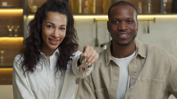 Happy Couple Shows Key From New Apartment in Kitchen