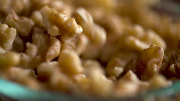 Slow motion footage of walnut pieces falling into a dish