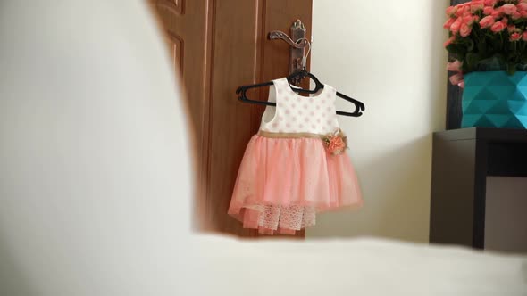 Peach Dress Hanging on the Door for Baby Girl
