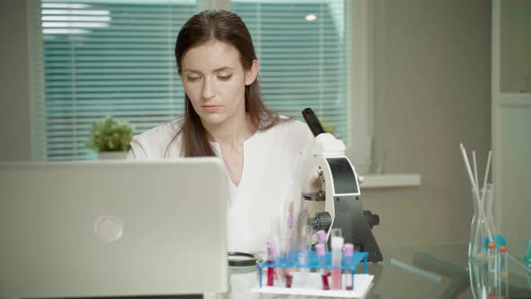 Female Doctor In Laboratory With Microscope
