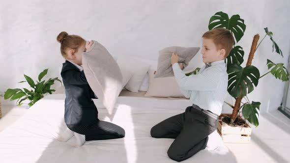 Children Are Having Fun Fighting with Pillows in a Room