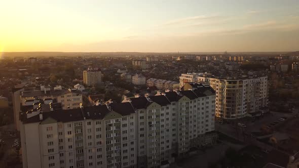 Aerial view of residential buildings in a city at sunset.