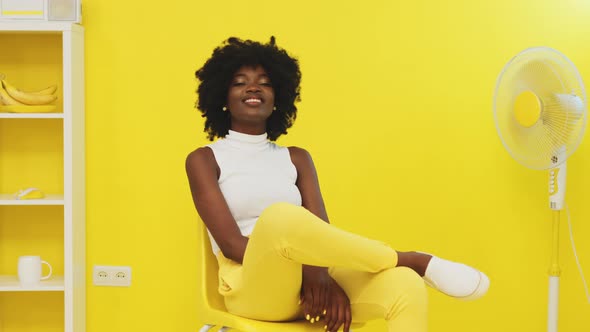 Happy Woman Is Sitting In Yellow Room and Smiling