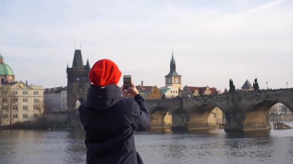 Prague Czech Young Woman at Charles Karlov Bridge Shooting with a Smartphone Smiling