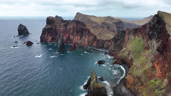 Drone tilt-down reveals dramatic sea cliffs of Ponta de São Lourenço, Madeira