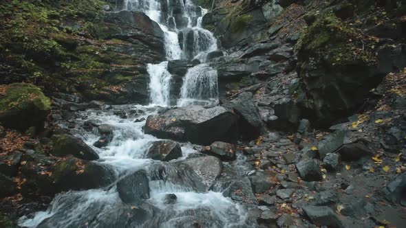 Foaming Mountain Waterfall Water Surrounded By Wet Stones