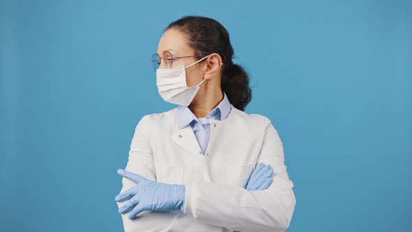 Professional Female Medical Doctor Wearing Protective Mask Turning Face to Camera Standing with