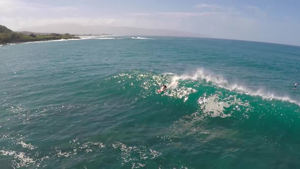 Aerial view of a man sup stand-up paddleboard surfing in Hawaii