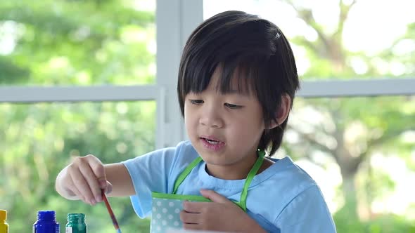 Cute Asian Boy Painting A Picture