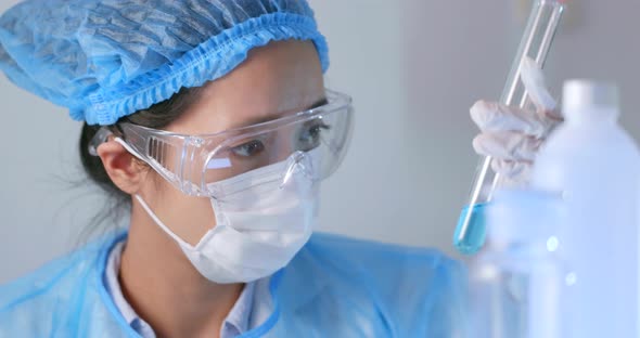 Female doctor analyzing liquid in test tube