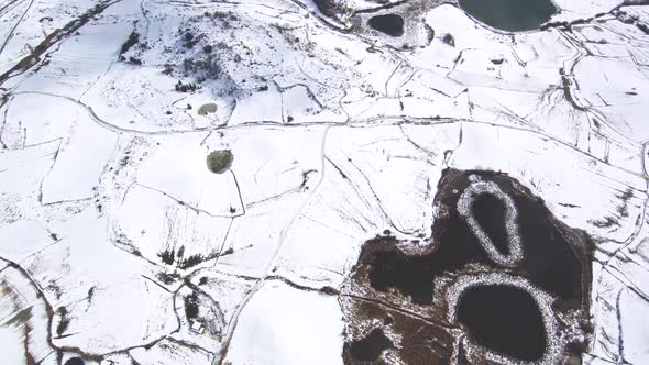 This is a footage of mountains in a snow day, you can also see big lakes and a village. This is in S