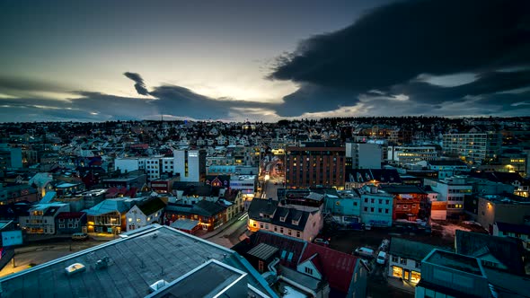 Dusk time lapse over Tromso city - lights turn on as darkness falls, car traffic