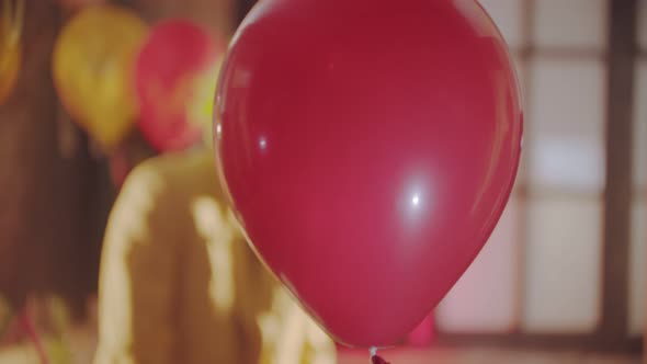 A Red Balloon Passing By - a Creepy Clown on the Background