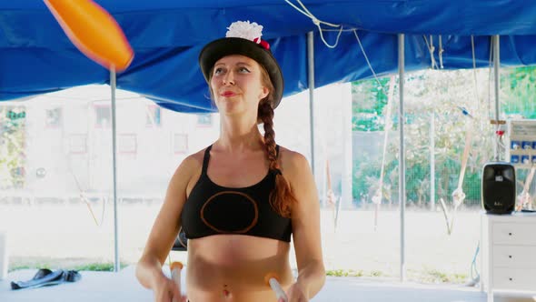 Pregnant circus artist juggling in tent