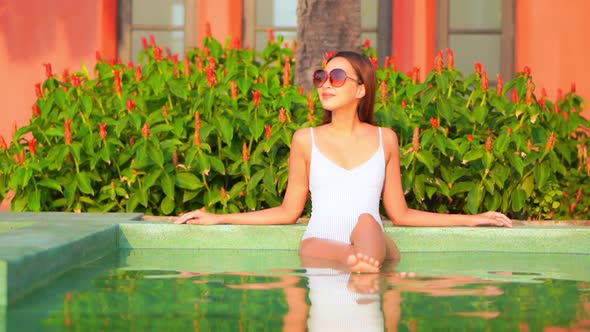 Young asian woman enjoy around outdoor swimming pool for leisure