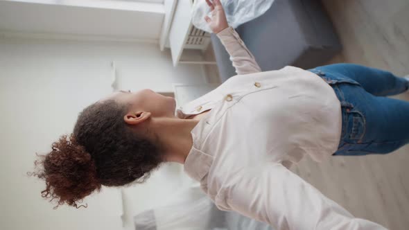 Woman Having Video Talk while Worker Carrying Boxes