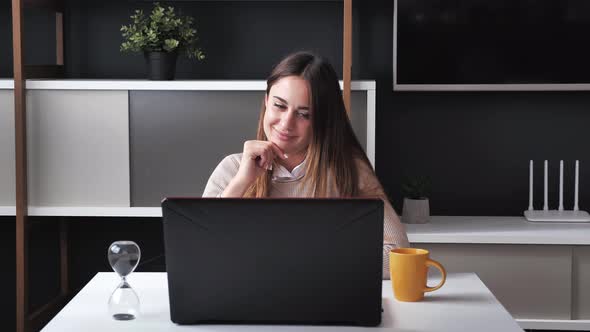 Millennial Woman Sitting at the Modern Office Used Laptop Rub your Chin Typing the Text