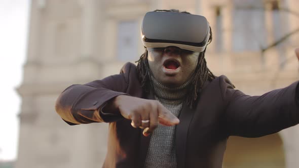 Scared African American Man with VR Headset Gesturing Like in Free Fall