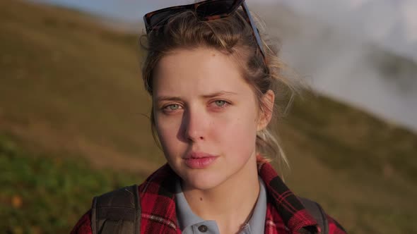 Portrait of Blonde Blueeyed Young Woman at Nature at Top of Mount Closeup of Face