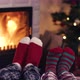 Couple feet in christmas woolen socks near fireplace with decorated tree in backg - VideoHive Item for Sale