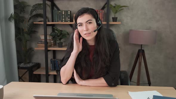 Smiling Young Business Woman Wear Wireless Headphone Video Conference Calling on Laptop Computer