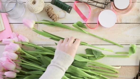 Time-lapse. Step by step. Florist wrapping pink tulips in bouquet