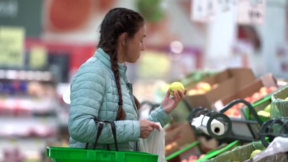 A Woman Chooses Fresh Apples in a Grocery Store Supermarket Sale Shopping Market Food