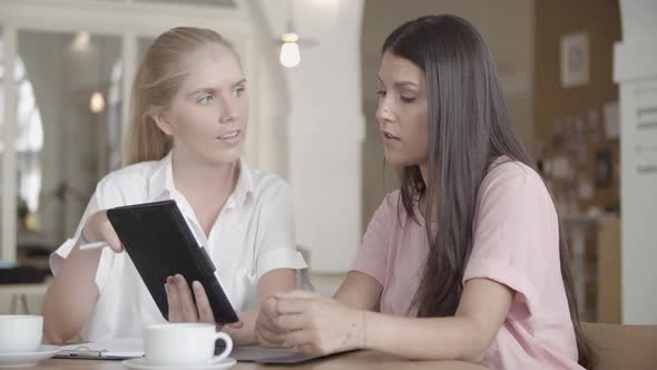 Content Blonde Woman Holding Tablet and Explaining Data