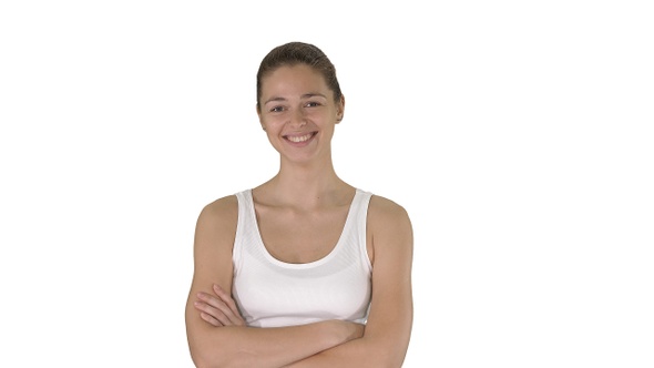 Smiling sports woman walking with arms folded on white background.