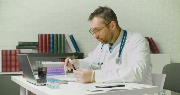 Dolly Shot of a Doctor Writes a Report in the Laboratory