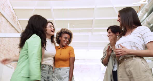 Group of Smiling Multiethnic Women Talking to Each Other in an Office