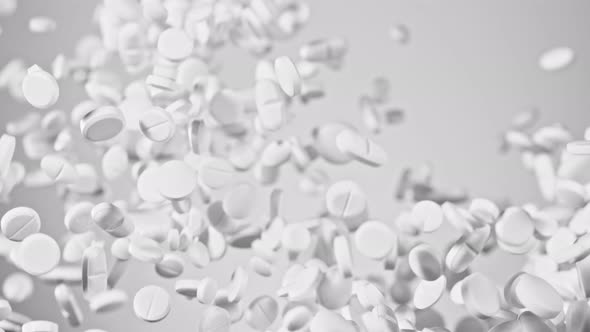 Super Slow Motion Shot of Flying White Pills on Gradient Grey Background at 1000Fps.