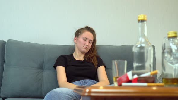 drunk woman after violent drinking session, with empty bottles, glasses