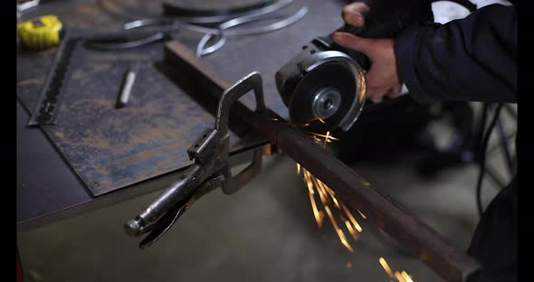 Woman Grinding Iron Pipe Using Grinder