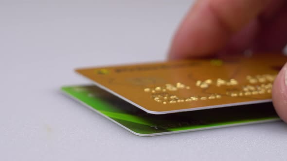 A Man's Hand Places a Stack of Credit Cards on the Table