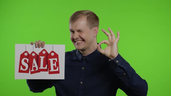 Happy Man Holding Sale Word Inscription and Showing Ok Sign. Guy Rejoicing with Good Sale Discounts