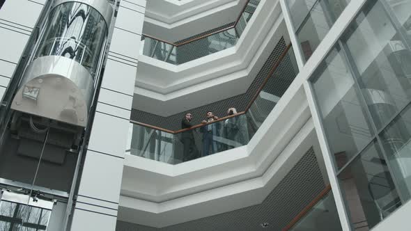 Business People Standing by Railing in Office