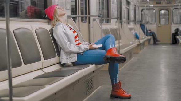 The Funny Attractive Joyful Blonde Girl Dancing in a Subway Car in Underground Metro. The Woman Is