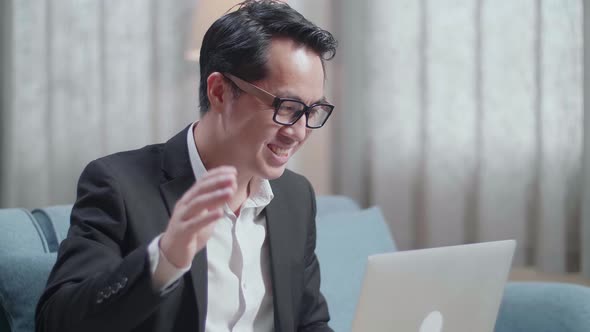 Close Up Of Asian Businessman In Jacket And Shorts Having Video Call On A Laptop At Home