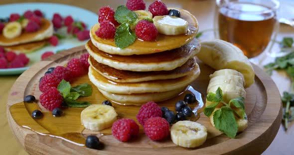 Pancakes are Served with Raspberries Banana Blueberry and Mint Leaf