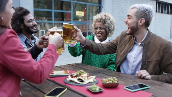 Happy Young People Celebrating Together While Drinking Beer After Work