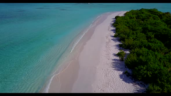 Aerial top down texture of luxury coastline beach vacation by turquoise lagoon and bright sandy back