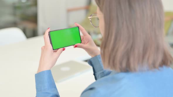 Young Woman Looking at Smartphone with Chroma Screen