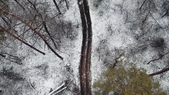 Female running in snowy winter park top aerial view training for marathon competition