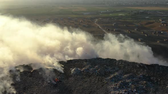 Aerial view of burning garbage pile in trash dump or landfill