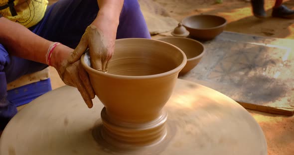 Skilled Hands of Potter Shaping the Clay on Potter Wheel and Sculpting Clay Pot Jar. Shilpagram