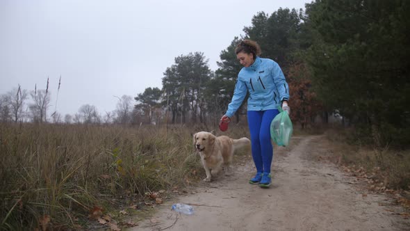 Female Jogger with Dog Doing Plogging in Woodland